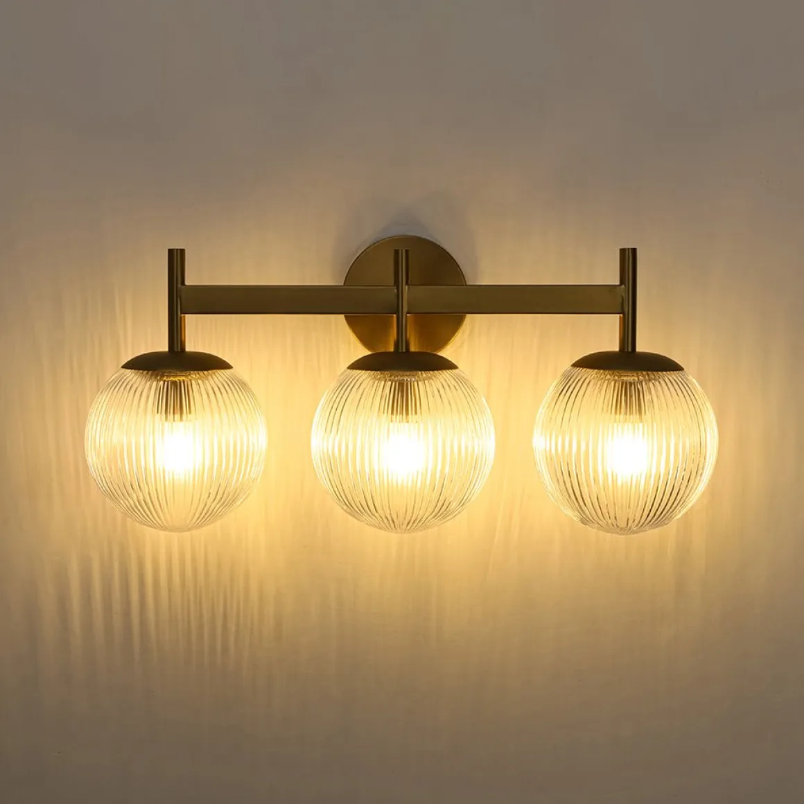 3-Light Brass Ribbed Glass Globe Vanity Wall Sconce